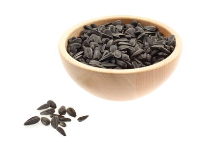 sunflower seeds in a wood bowl. white backgroundの写真素材