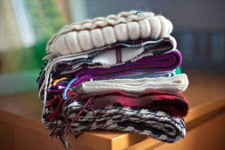multicolor warm scarfs collection on a wood table in a roomの写真素材