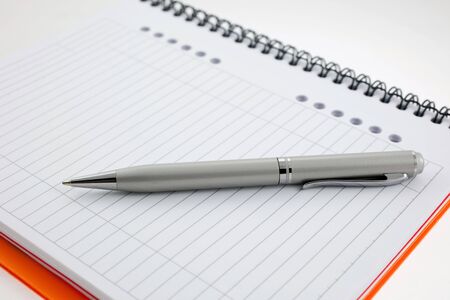 silver pen and paper orange notebook. small GRIPの写真素材