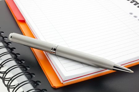 silver pen and two paper notebooks: orange and blackの写真素材