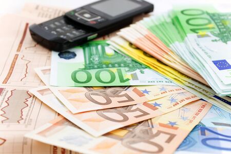 euro notes and black mobile phone on a financial newspaper. closeup. small GRIPの写真素材