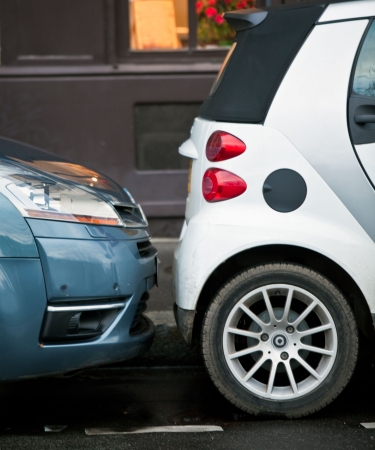 two closely parking cars on a street of Parisの写真素材