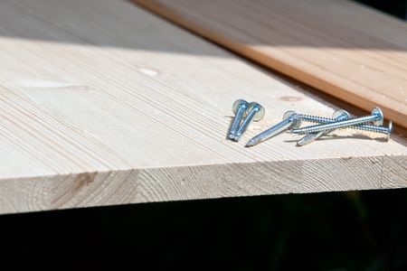 six steel screws on a wooden plank. horizontal closeup shotの写真素材