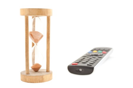 TV remote panel and old wood sandglass isolated