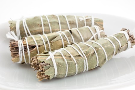 three dry bouquets garni cotton knotted on a white dishの写真素材