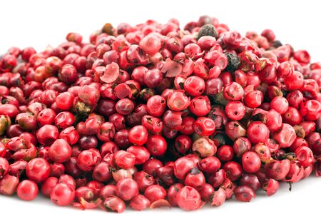 heap of pink pepper in corns closeup on a white backgroundの写真素材