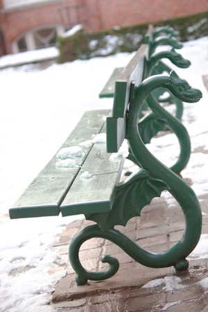 green bench with ornamental dragons at winter park in Bruggeの写真素材