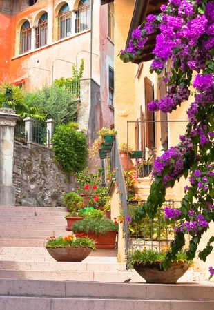 traditional italian small town street with pots of flowersの写真素材