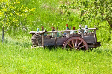 Tuscany landscape: Old Rustic wagon with wine bottlesの写真素材