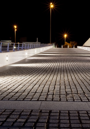 Empty stone pavement at night. Lamp light and shadows.の写真素材