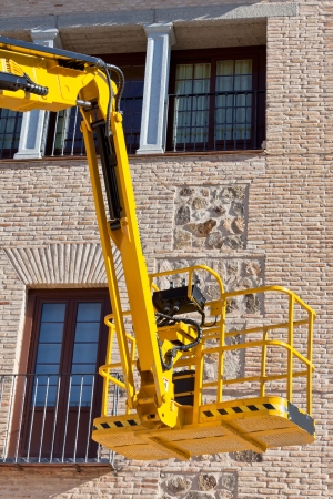 Hydraulic platform equipment against building wall. Vertical shotの写真素材