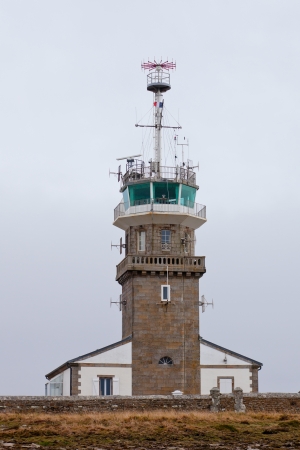Old stone lighthouse with modern equipment at dull day. Cape Ra, (Pointe du Raz), westernmost France pointの写真素材