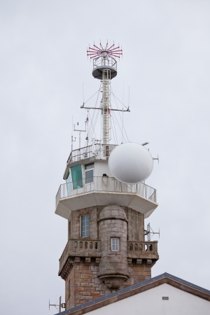 Old stone lighthouse with modern equipment at dull dayの写真素材