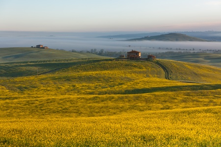 Morning fog view on farmhouse at Valley d?Orcia in Tuscany, Italyの写真素材