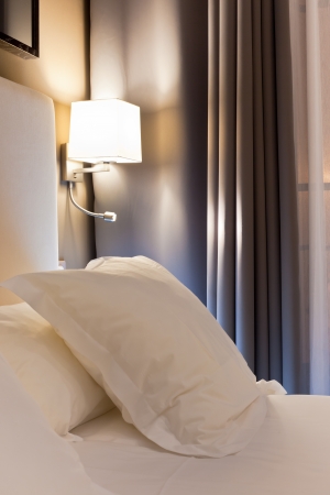 Night scene in hotel room, nightstand with lampの写真素材