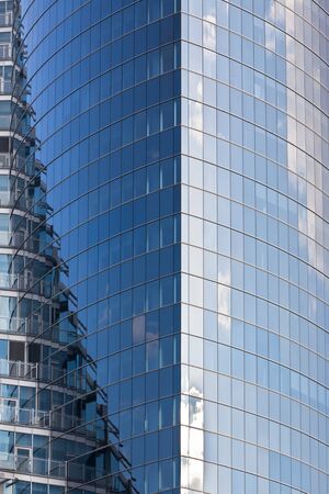Building reflections in the glass skyscraper wall. Vertical shotの写真素材