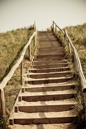 Stairs to the top of a dune. Netherlands. Toned and vignetted image