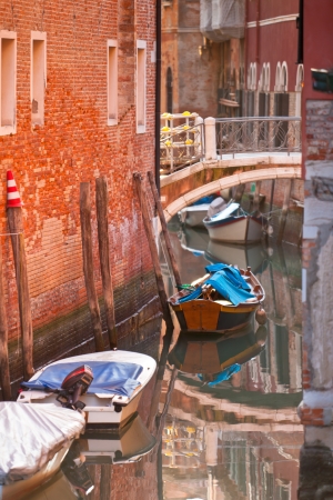 Bridge over a Venetian Canal. Reflections are on the water.の写真素材