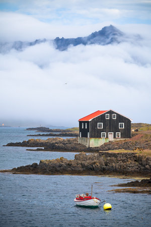 Lonely Black Wooden House at coastlineÊin East Iceland. Vertical shotのeditorial素材