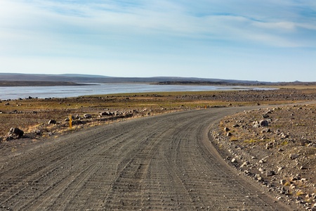 Iceland Dirt Road through Stone Field and a River. Bright Blue Skyの写真素材