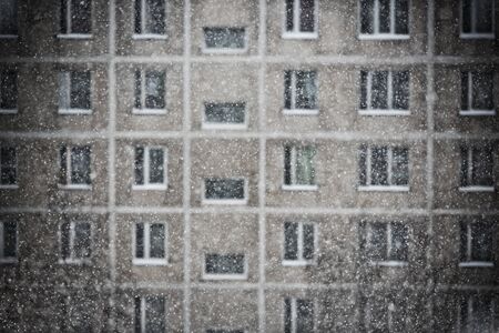 Snowfall on a residential building facade background. Winter moodの写真素材