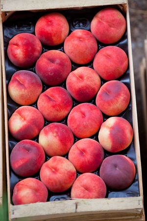 Fresh nectarines selling in a market. Vertical shot with a selective focusの写真素材
