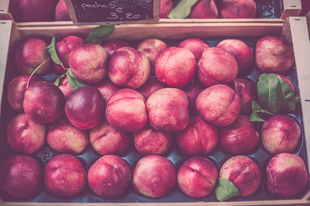 Ripe fresh nectarines in a farmers market. Horizontal filtered shot with a selective focusの写真素材
