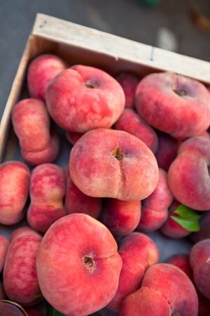 Fresh peaches selling in a market. Vertical filtered shot with a selective focusの写真素材