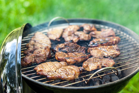 Grilling pork meat with barbecue stuff. Horizontal close up shotの写真素材