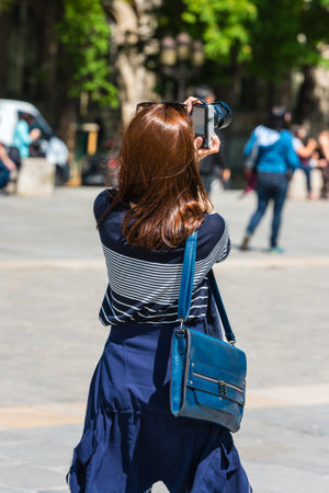 FRANCE, PARIS - JUNE 01: Back side of a young woman taking a photo with her camera in Paris on June 01, 2015のeditorial素材