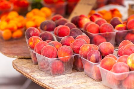 Ripe fresh peaches in a farmers market. Horizontal shot with a selective focusの写真素材