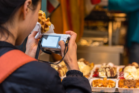 BELGIUM, BRUSSELS - MAY 25: Back side of young woman taking a photo of belgian waffles in Brussels on May 25, 2015のeditorial素材