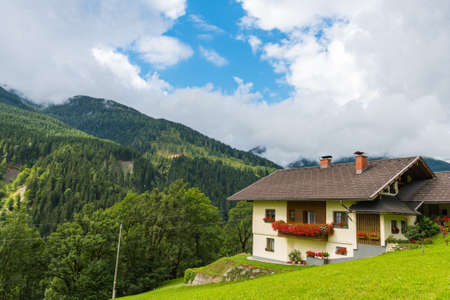 Traditional alpine house in green forest mountains. Horizontal shotの写真素材