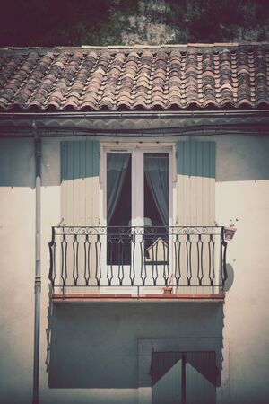 House facade with window and balcony in Southern France. Vertical filtered shotの写真素材
