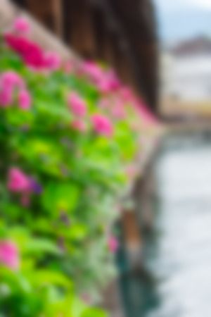 Flowers on The famous wooden Chapel Bridge Kapellbrucke in Lucerne city in Switzerland. Defocused blur imageの写真素材