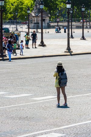 FRANCE, PARIS - JUNE 06: Back side of a young woman taking a photo with her camera in Paris on June 06, 2015のeditorial素材