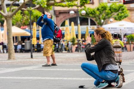 GERMANY, FRANKFURT - MAY 24: Young woman taking a photo with her phone in Frankfurt on May 24, 2015のeditorial素材