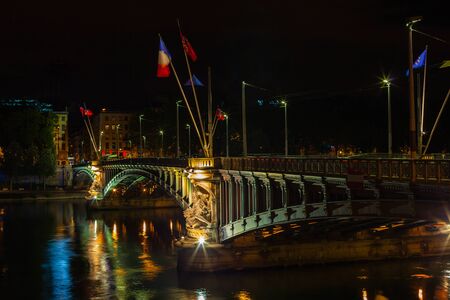Cityscape of Lyon, France with reflections in the water at night