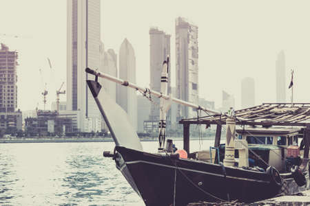 Abu Dhabi buildings skyline with old fishing boat on the front