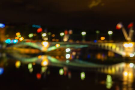 Defocused Cityscape of Lyon, France with reflections in the water at night