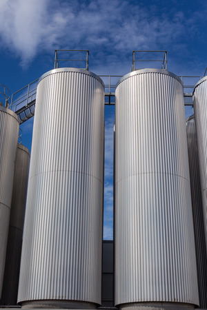 Giant industrial tanks on the bright blue sky background