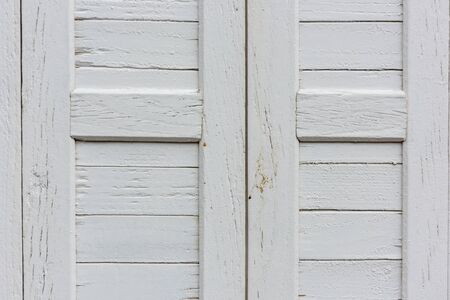 window with closed beige wooden shutters. background photoの写真素材