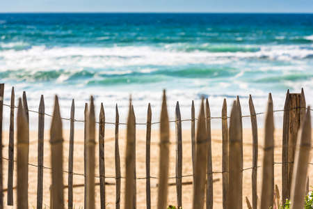 Wooden fence on an Atlantic beach in France, The Gironde Department. Shot with a selective focus