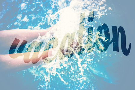 Word Vacation on blurred background of female legs splashing sea waterの写真素材