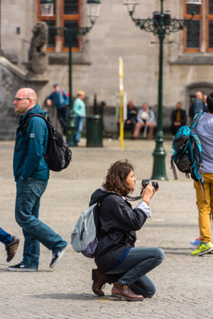 BELGIUM, BRUGES - MAY 22: Woman is taking pictures on the street of Bruges on May 22, 2015のeditorial素材