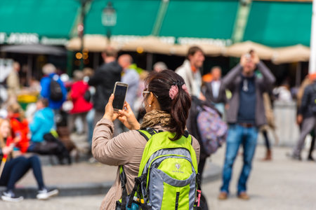 BELGIUM, BRUGES - MAY 22: Woman is taking pictures on the street of Bruges on May 22, 2015のeditorial素材
