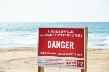FRANCE, ONDRES - SEPTEMBER 18: Red danger sign on an ocean beach with waves on the background on September 18, 2015のeditorial素材