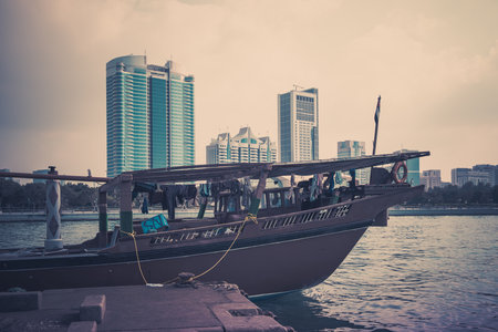 Abu Dhabi buildings skyline with old fishing boats on the front. Filtered shotのeditorial素材