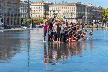 FRANCE, BORDEAUX - SEPTEMBER 20: People having fun in a mirror fountain in front of Place de la Bourse in Bordeaux, France on September 20, 2015のeditorial素材