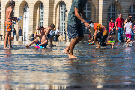 FRANCE, BORDEAUX - SEPTEMBER 20: People having fun in a mirror fountain in front of Place de la Bourse in Bordeaux, France on September 20, 2015のeditorial素材